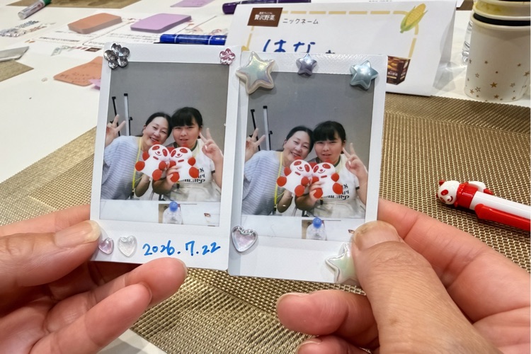 お土産のチェキのペア写真に、シールやペンでデコレーションした様子