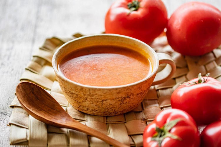 「クノール®贅沢野菜®」＜完熟トマト＞のイメージ。カップに注がれたトマトのスープと、完熟トマト