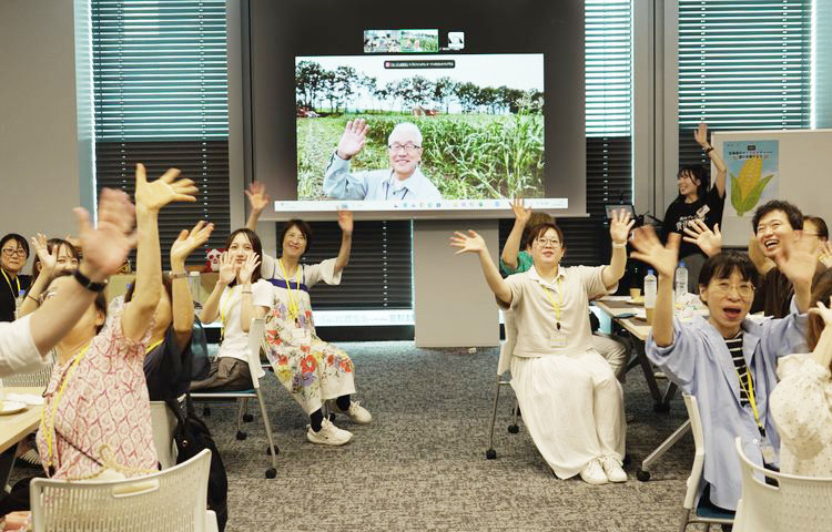 スクリーンの立川さんに向かって、笑顔で手を振る参加者のみなさん